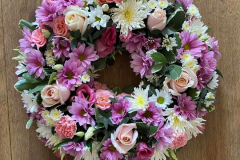 Funeral wreath created using a mix of pinks & white seasonal flowers.