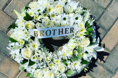 White & green funeral wreath. Complete with a white Brother sash.