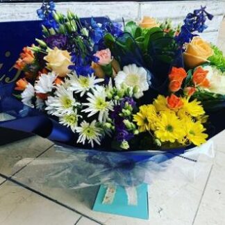 Aqua Bouquet with a mix of seasonal flowers in blue, purple. yellow, cream & oranges.