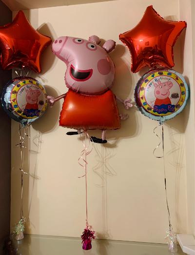 Two red star balloons, two round Peppa balloons & one large Peppa Pig character balloon.