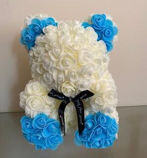 Cream bear with blue paws & ears. complete with a black bow.