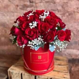Red hatbox filled with red roses and gypsophila and a dash of greenery