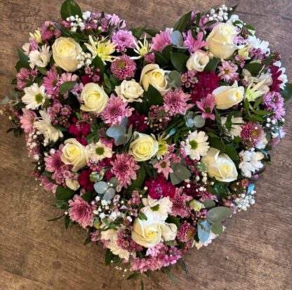 Funeral heart tribute it is a full heart filled with a mixed flowers and foliage.