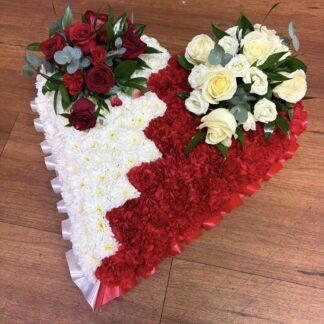 Funeral Heart Arrangement. Spit in two colours one side red the other side white. With rose sprays on each side, red roses on the white side and white roses on the red side.